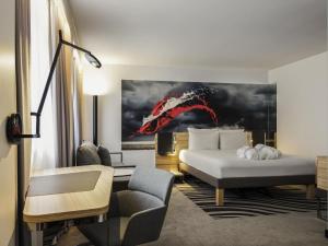 una habitación de hotel con una cama y una silla en Novotel Den Haag City Centre, en La Haya