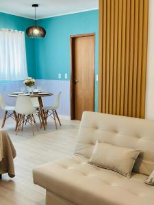 una sala de estar con un sofá y una mesa en Studio Aconchego Praia Grande, en Praia Grande