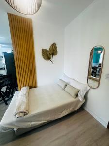 Cama en habitación con espejo en la pared en Studio Aconchego Praia Grande, en Praia Grande
