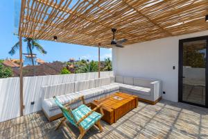 a patio with a couch and a table and chairs at Villa Tin in Pererenan