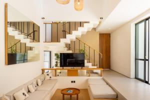 a living room with a couch and a staircase at Villa Tin in Pererenan
