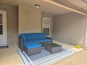 a porch with a blue couch on a patio at The Bama Bungalow 3BD Walk to the Game, Stay in Style in Tuscaloosa