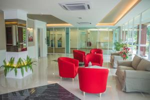 a lobby with red chairs and a table at Qlassic Hotel in Sepang