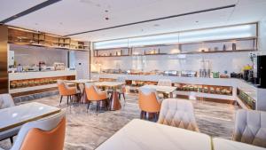 a restaurant with tables and chairs and a kitchen at Elong Hotel Beijing Chang'an Tianjie Bridge Huiying Metro Station Branch in Beijing