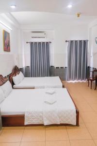 een slaapkamer met 2 bedden en een tafel bij Tân Ty Mon Hotel in Ho Chi Minh-stad +19 foto's