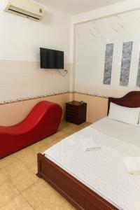 a bedroom with a bed and a tv on the wall at Tân Ty Mon Hotel in Ho Chi Minh City