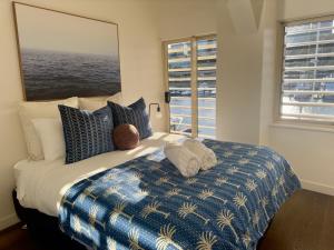 a bedroom with a bed with a large window at Harbour View Woolloomooloo in Sydney