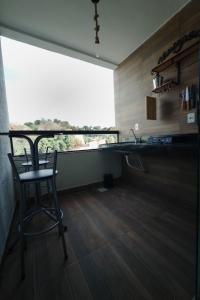 ゴベルナドール・バラダレスにあるApartamento com piscinaのカウンターとスツールと窓のあるキッチン