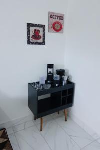 ゴベルナドール・バラダレスにあるApartamento com piscinaのコーヒーメーカーが置かれた黒いキャビネット