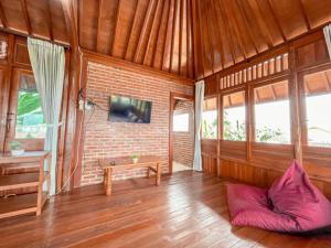 a living room with a couch and a tv on a brick wall at Arovala Villa in Padasul