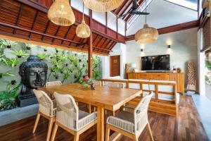 a dining room with a wooden table and chairs at Dua villas Bali - Modern Balinese Escape in Canggu