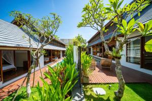 an exterior view of a house with a courtyard with trees at Dua villas Bali - Modern Balinese Escape in Canggu