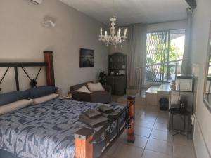 une chambre avec un grand lit et un salon dans l'établissement Ormonde guesthouse, à Pretoria
