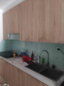 a kitchen counter with a sink and wooden cabinets at Linh Kinh Bắc in Hòa Bình