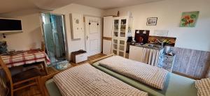 ein kleines Zimmer mit 2 Betten und einer Küche in der Unterkunft Sonniges Appartement und Gästezimmer, Haus Borowiec 