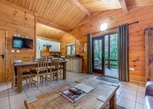 a dining room and kitchen in a log cabin at Quarry Walk Lodges in Cheadle