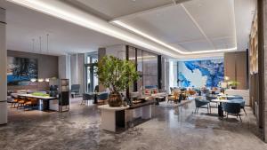 a lobby of a hotel with tables and chairs at Crowne Plaza Weihai Binhai by IHG in Weihai