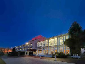 a hotel building with a sign on it at night at Mercure Rouen Val de Reuil in Val de Reuil