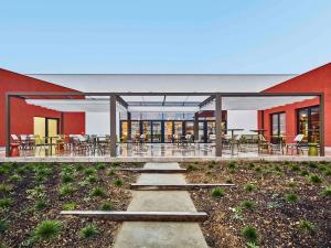 un edificio con un patio con mesas y sillas en Mercure Paris Orly Airport, en Orly