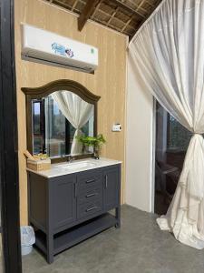 a bathroom with a sink and a mirror at Khu nghỉ dưỡng sinh thái Apsara Sóc Trăng in Ấp Vĩnh Hưng