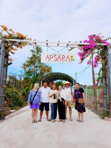 un grupo de personas posando para una foto bajo un arco en Khu nghỉ dưỡng sinh thái Apsara Sóc Trăng, en Ấp Vĩnh Hưng