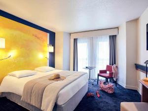 a hotel room with a bed with a hat on it at Mercure Rouen Centre Cathédrale in Rouen +96 photos