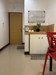 a kitchen with a red chair and a door at Makati One Poblacion Hotel in Manila +11 photos