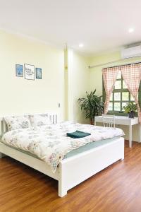 Una cama blanca en una habitación con ventana. en HCA Homestay, en Ha Giang