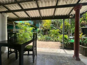 une table et des chaises noires sous une pergola dans l'établissement Green Garden Guest Mirissa, à Mirissa