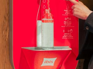 Una licuadora roja con una botella encima. en ibis Lyon Part Dieu Les Halles, en Lyon