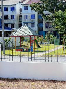 a playground behind a fence in front of a building at EQAMEL Homestay Corner Lot in Sandakan