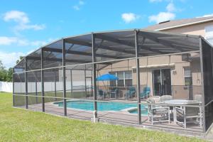 a metal pavilion with a pool and a table at Berkeley Pool Home home in Kissimmee