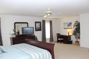 a bedroom with a bed and a ceiling fan at Berkeley Pool Home home in Kissimmee +24 photos