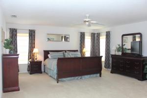 a bedroom with a bed and a mirror and a tv at Berkeley Pool Home home in Kissimmee