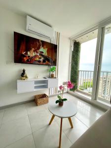 Estación El SaltoにあるSunset 47 - Vista al mar cerca del Centro Históricoのテレビとテーブルのあるリビングルーム