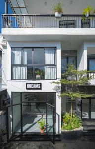 フエにあるDreams Homestay with Full Kitchen & Big Loungeの「夢」と書かれた看板のある白い建物