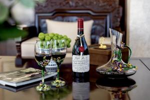 a bottle of wine and two glasses on a table at Boying happywin Guofeng Shangyuan Lijiang Ancient Town South Gate Store in Lijiang +27 photos