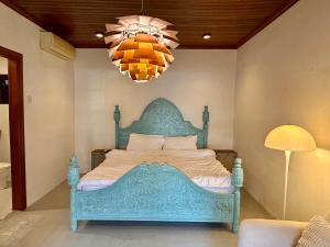 ペタリンジャヤにあるChic Designer Family Suite in Shared Bungalow near LRT SS1 PJのシャンデリア付きのベッドルームの青いベッド1台