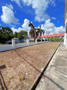 a white fence with two palm trees on top of it at EQAMEL Homestay Corner Lot in Sandakan +3 photos