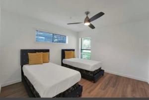 Cette chambre dispose de 2 lits et d'un ventilateur de plafond. dans l'établissement Spacious 3BR Oasis Pool Fire Pit & Family Fun, à Cowley