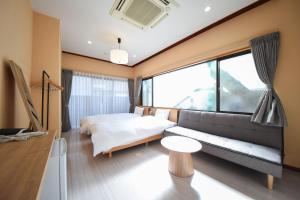 a bedroom with a couch and a bed and a window at Setolive別邸 by 4S STAY in Takamatsu