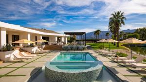 a house with a swimming pool and chairs at Buena Vista by AvantStay Massive Outdoor Oasis w Pool Spa Firepit in La Quinta