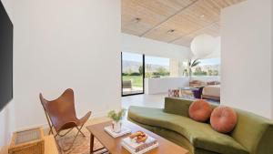a living room with a green couch and a table at Buena Vista by AvantStay Massive Outdoor Oasis w Pool Spa Firepit in La Quinta