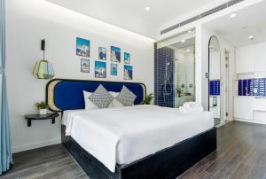 a bedroom with a large bed with a blue headboard at Atermis Regency Hillside Phu Quoc - Sea & Fireworks view- Gym & Pool Access in Phu Quoc