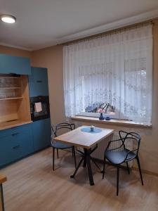 cocina con mesa, 2 sillas y ventana en Mieszkanie w centrum Gogolina, en Gogolin