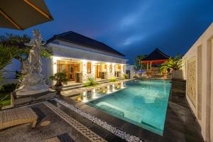 a villa with a swimming pool at night at Cove Dharma Kencana in Ungasan