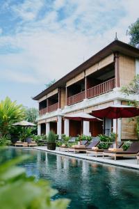 a resort with a swimming pool in front of a building at Sanubari Ubud in Ubud
