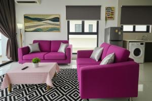 a living room with two purple couches and a table at Danga Bay The Sunny Coast 3BR 8Pax by Our Stay in Johor Bahru