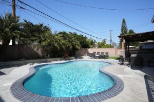 a swimming pool in a backyard with chairs around it at Destination #16 in Anaheim