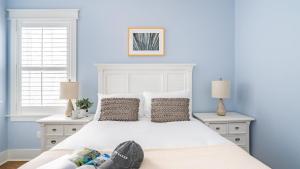 Un dormitorio con una cama blanca y dos ventanas. en Pearl by AvantStay Idyllic Seaside Getaway w 2 Large Decks Lush Garden, en Seagrove Beach 32 fotos más
